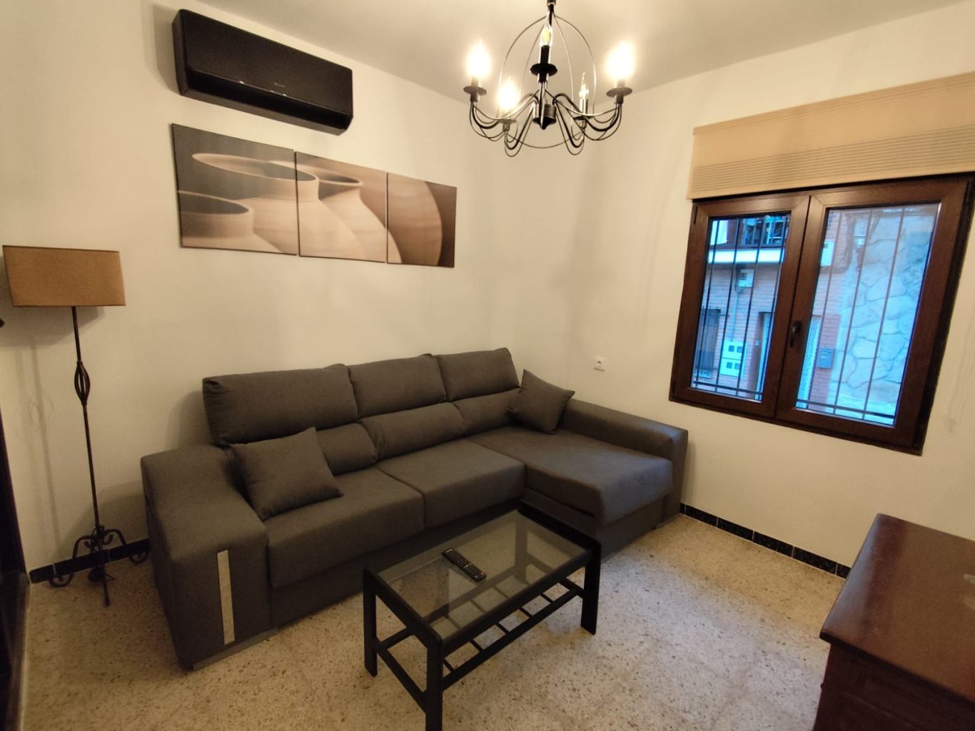 Salon Sofá para 4 personas, mesa de centro y l-ampara de pie en salón de vivienda